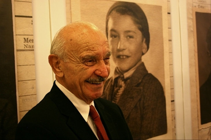 Benny Goren (Grunhut) stands in front of photo of himself as a child at the opening of the Aron Grunhut exhibition in Bratislava.